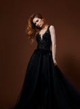 Beautiful Elegant Young Model With Bright Redhead Hairstyle Posing In Fashion Chic Black Wedding Dress With Long Skirt On Studio Royalty Free Stock Photography