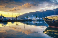 Beautiful evening landscape with yachts, golden clouds and reflections in water. Montenegro, Tivat, marina Porto Montenegro stock image Beautiful evening landscape with yachts, golden clouds and reflections in water. Montenegro, Tivat, marina Porto Montenegro stock image