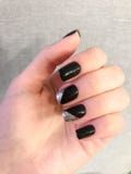 Beautiful female hand with thin fingers and black manicure with gel polish with silver sparkles on the nails royalty free stock image Beautiful female hand with thin fingers and black manicure with gel polish with silver sparkles on the nails royalty free stock image
