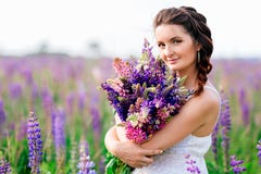 Beautiful girl with bouquet of lupine flowers in hands stock photo Beautiful girl with bouquet of lupine flowers in hands stock photo