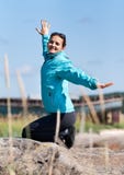 Beautiful girl in a jacket kneeling on a rock Royalty Free Stock Photo Beautiful girl in a jacket kneeling on a rock Royalty Free Stock Photo