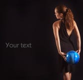 Beautiful girl keeps blue soccer ball on black bac royalty free stock photography Beautiful girl keeps blue soccer ball on black bac royalty free stock photography