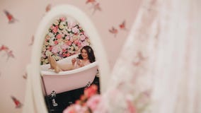 Beautiful girl lying in the bath with phone in hand. A smile on his face. Funny footage. stock video footage Beautiful girl lying in the bath with phone in hand. A smile on his face. Funny footage. stock video footage