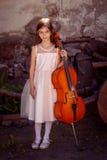 Beautiful girl in a pink dress with a cello