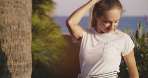 Beautiful girl posing at palm tree on background of sea stock video footage Beautiful girl posing at palm tree on background of sea stock video footage