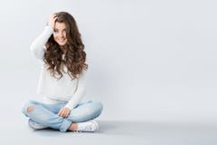 Beautiful girl sitting on the floor cross-legged. Royalty Free Stock Image Beautiful girl sitting on the floor cross-legged. Royalty Free Stock Image