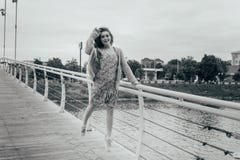 Beautiful girl stands on the bridge, the wind blows in her face, developing her hair. girl smiles. dancing black and white photo stock photos Beautiful girl stands on the bridge, the wind blows in her face, developing her hair. girl smiles. dancing black and white photo stock photos