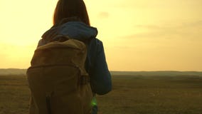 Beautiful girl traveler with a backpack goes on foot at sunset. Tourist girl. Concept in the campaign. Freedom and stock video footage Beautiful girl traveler with a backpack goes on foot at sunset. Tourist girl. Concept in the campaign. Freedom and stock video footage