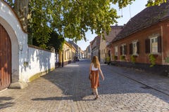 Beautiful girl walking down the empty town of Varazdin streets during hot, summer day in the old, historical city center full of