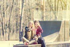 Beautiful girls in casual clothes doing selfie at skate park Stock Images Beautiful girls in casual clothes doing selfie at skate park Stock Images