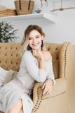 Beautiful, Happy And Smiling Blonde Model Girl With Blue Eyes And With Fashionable Earrings In A Beige Stylish Dress Stock Photos Beautiful, Happy And Smiling Blonde Model Girl With Blue Eyes And With Fashionable Earrings In A Beige Stylish Dress Stock Photos