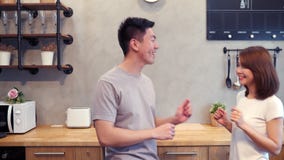 Beautiful happy asian couple are dancing in the kitchen at home. Young asian couple have romantic time listening music at home. stock video Beautiful happy asian couple are dancing in the kitchen at home. Young asian couple have romantic time listening music at home. stock video