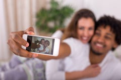 Beautiful happy couple waking up and taking a selfie in the bedroom royalty free stock images Beautiful happy couple waking up and taking a selfie in the bedroom royalty free stock images