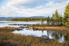 A beautiful lake landscape in Femundsmarka National Park in Norway. Lake with a distant mountains in background. Royalty Free Stock Photo A beautiful lake landscape in Femundsmarka National Park in Norway. Lake with a distant mountains in background. Royalty Free Stock Photo