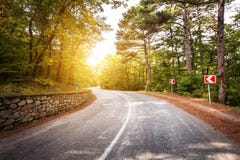 Beautiful landscape with asphalt road,green forest and road sign at colorful sunrise in summer. Crimean mountains. Stock Photo Beautiful landscape with asphalt road,green forest and road sign at colorful sunrise in summer. Crimean mountains. Stock Photo