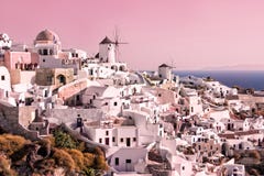 Beautiful landscape with white buildings and vintage windmills in Oia on Santorini island, Greece at sunset stock photography Beautiful landscape with white buildings and vintage windmills in Oia on Santorini island, Greece at sunset stock photography