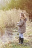 Beautiful little girl fishing with spinning on the river stock photos Beautiful little girl fishing with spinning on the river stock photos