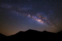 Beautiful milky way galaxy and silhouette of high moutain on a n