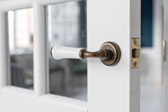 Beautiful modern door knob. Open, wooden front door from the interior of an upscale home with windows. Stock Photography Beautiful modern door knob. Open, wooden front door from the interior of an upscale home with windows. Stock Photography