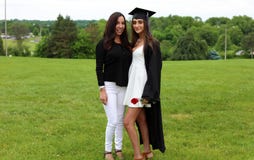 Beautiful Mother And Daughter In Black Cap, Gown And Tass, Teenager. Unique Gorgeous Face, Nice Smile, Wonderful Eyes Girl. Stock Photo Beautiful Mother And Daughter In Black Cap, Gown And Tass, Teenager. Unique Gorgeous Face, Nice Smile, Wonderful Eyes Girl. Stock Photo