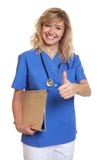 Beautiful nurse with curly blonde hair and medical file showing thumb stock photos Beautiful nurse with curly blonde hair and medical file showing thumb stock photos