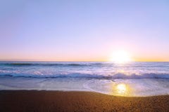 Beautiful panoramic seascape with waves and golden sunset. Reflection of sun in the water. Sea landscape
