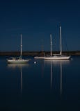 Boats reflecting on moonlit night in peaceful bay royalty free stock photo Boats reflecting on moonlit night in peaceful bay royalty free stock photo