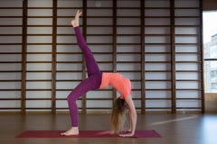 Beautiful photo of young lady standing in bridge exercise while practicing yoga poses on yoga mat stock image Beautiful photo of young lady standing in bridge exercise while practicing yoga poses on yoga mat stock image