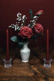 Beautiful pink roses in a vase acsented with Baby`s Breath flowers, Two red candles in crystal holder royalty free stock images Beautiful pink roses in a vase acsented with Baby`s Breath flowers, Two red candles in crystal holder royalty free stock images