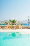 Beautiful pool with chairs near the sea on the island of Mykonos i royalty free stock photo Beautiful pool with chairs near the sea on the island of Mykonos i royalty free stock photo