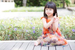 Beautiful portrait little girl asian of a smiling standing on green grass at the park. Stock Photo Beautiful portrait little girl asian of a smiling standing on green grass at the park. Stock Photo