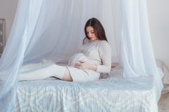 Beautiful Pregnant Woman Expecting Baby. Sitting on bed with canopy. Maternity concept. royalty free stock photo Beautiful Pregnant Woman Expecting Baby. Sitting on bed with canopy. Maternity concept. royalty free stock photo