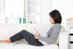 Pregnant woman holding headphones at her belly stock photo