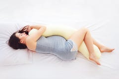 Beautiful pregnant woman sleeps comfortable with tummy supporting pillow stock image Beautiful pregnant woman sleeps comfortable with tummy supporting pillow stock image