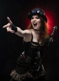 Beautiful redhead cosplayer girl wearing Victorian-style steampunk costume with a big breast in a deep neckline screams and holds stock photo Beautiful redhead cosplayer girl wearing Victorian-style steampunk costume with a big breast in a deep neckline screams and holds stock photo