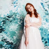 Beautiful and romantic bride in wedding dress with long sleeves. Young redheaded woman in wedding dress stock photo Beautiful and romantic bride in wedding dress with long sleeves. Young redheaded woman in wedding dress stock photo