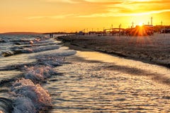 Scenic landscape of sandy beach at Anapa resort on Black Sea coast with surfing waves and people on seashore. Summer sunset seasid royalty free stock photos Scenic landscape of sandy beach at Anapa resort on Black Sea coast with surfing waves and people on seashore. Summer sunset seasid royalty free stock photos