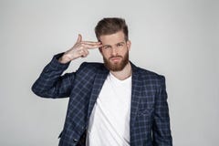 Beautiful sexy bearded man with a beautiful hair style. holds his hand at his head as if it`s a pistol and wants to kill himself stock image Beautiful sexy bearded man with a beautiful hair style. holds his hand at his head as if it`s a pistol and wants to kill himself stock image
