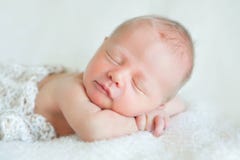 A beautiful sleeping newborn baby boy on a white blanket. He is Royalty Free Stock Images A beautiful sleeping newborn baby boy on a white blanket. He is Royalty Free Stock Images