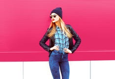 Beautiful stylish blonde woman in rock black style jacket, hat posing on city street over colorful pink wall royalty free stock photos Beautiful stylish blonde woman in rock black style jacket, hat posing on city street over colorful pink wall royalty free stock photos