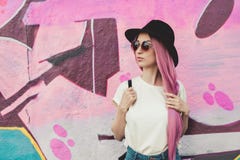 Beautiful stylish young hipster woman with long pink hair, hat and sunglasses on the street. royalty free stock images Beautiful stylish young hipster woman with long pink hair, hat and sunglasses on the street. royalty free stock images