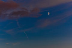 Beautiful sunset with orange clouds, deep blue sky and moon. Royalty Free Stock Photos Beautiful sunset with orange clouds, deep blue sky and moon. Royalty Free Stock Photos