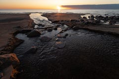 Beautiful sunset with red sand and spring water from a river exiting to the sea - Veczemju Klintis, Latvia - April 13 royalty free stock image Beautiful sunset with red sand and spring water from a river exiting to the sea - Veczemju Klintis, Latvia - April 13 royalty free stock image