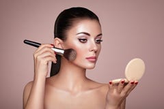 Beautiful Woman applies Skin Tone with Brush Stock Image Beautiful Woman applies Skin Tone with Brush Stock Image