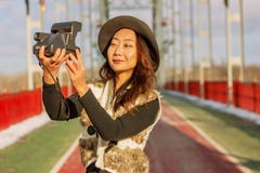 Beautiful woman in black hat makes a polaroid selfie on a bridge in the winter in Europe. royalty free stock photography Beautiful woman in black hat makes a polaroid selfie on a bridge in the winter in Europe. royalty free stock photography