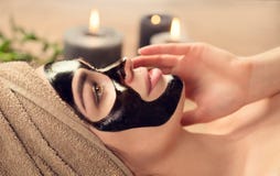 Beautiful woman with black purifying black mask on her face. Beauty model girl with black facial peel-off mask lying in spa salon royalty free stock photo Beautiful woman with black purifying black mask on her face. Beauty model girl with black facial peel-off mask lying in spa salon royalty free stock photo