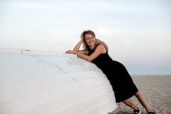 Beautiful woman in black summer dress on the beach near white wooden boat royalty free stock photo Beautiful woman in black summer dress on the beach near white wooden boat royalty free stock photo