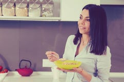 Beautiful young woman having breakfast in the kitchen. stock photo Beautiful young woman having breakfast in the kitchen. stock photo