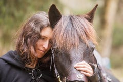 Beautiful Woman In Historical Costume As A Warrior Hugs His Horse Stock Photo