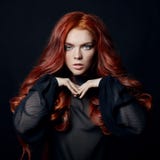 Beautiful woman with red hair on a black background. Portrait of Stock Image Beautiful woman with red hair on a black background. Portrait of Stock Image